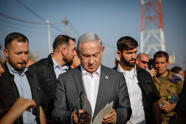 Israeli prime minister Benjamin Netanyahu surrounded by aides and bodyguards.