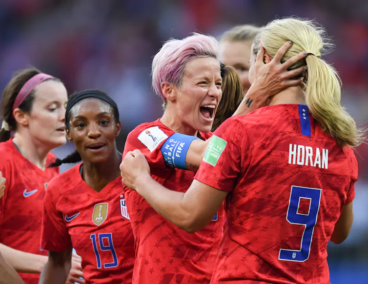 Women footballers in red kit celebrating