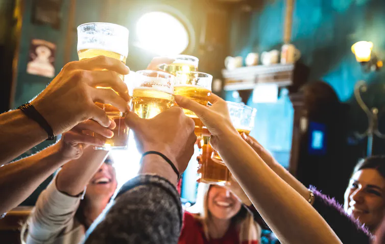 Multiple hands raised with glasses.