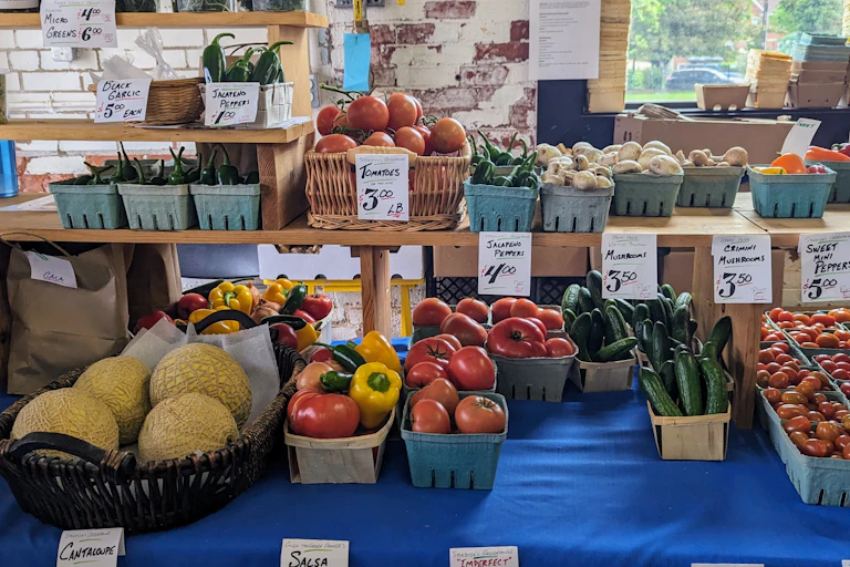 Photo of assorted produce at an indoor farmers' market stand.