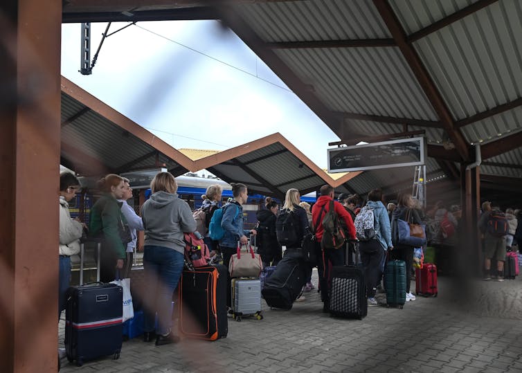 A line of people at a train station.