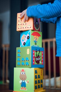A child stacks blocks in a tower.