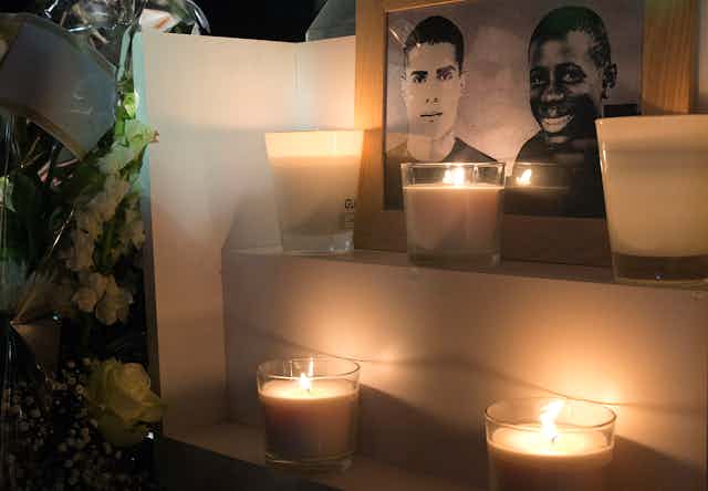 Une photo prise le 26 octobre 2015 à Clichy-sous-Bois montre des fleurs et des bougies placées près d'une plaque érigée à la mémoire de Bouna Traore (R) et Zyed Benna, deux adolescents locaux qui sont morts en fuyant la police le 27 octobre 2005. 