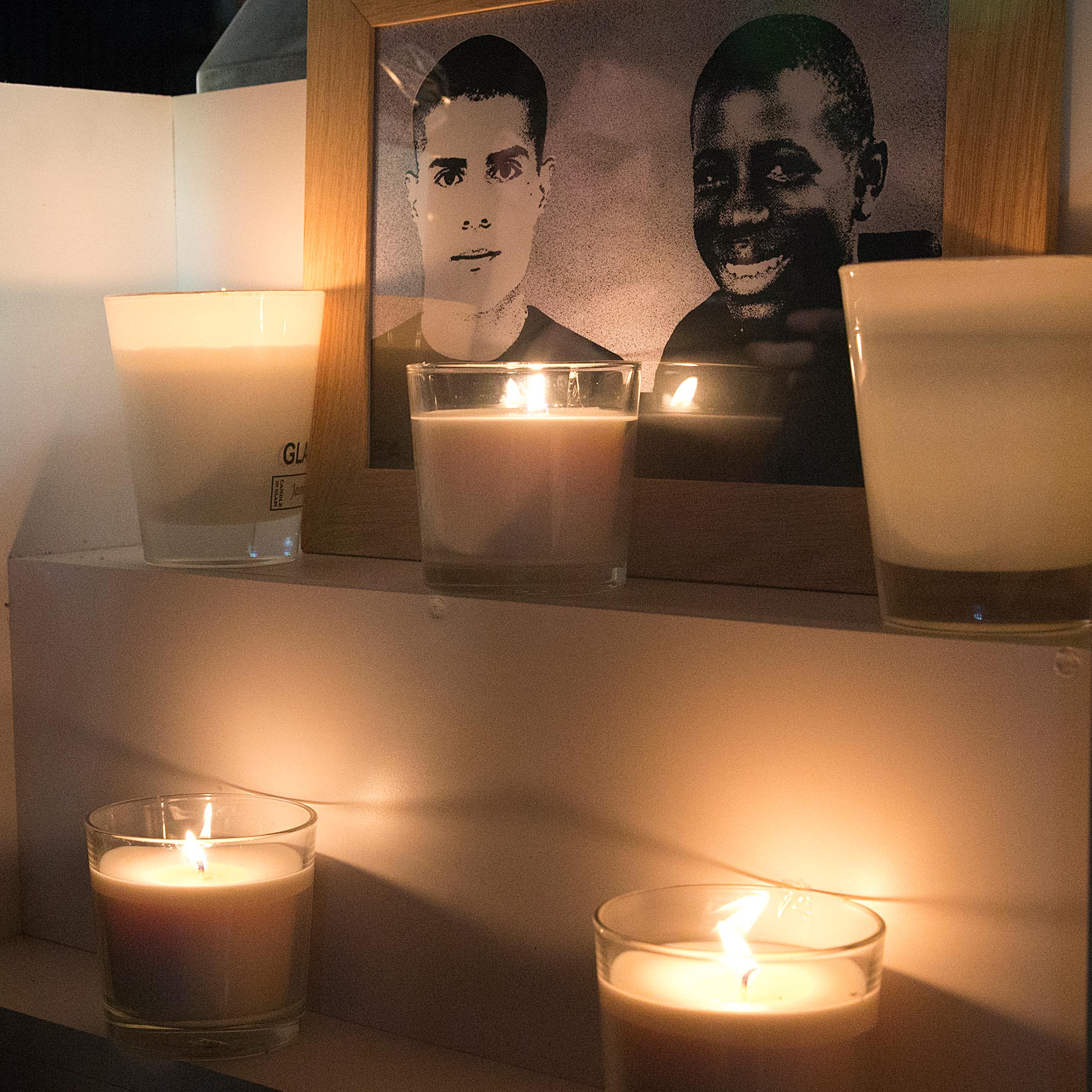 Une photo prise le 27 octobre 2015 à Clichy-sous-Bois montre des fleurs et des bougies placées près d'une plaque érigée à la mémoire de Bouna Traore (R) et Zyed Benna, deux adolescents locaux qui sont morts en fuyant la police le 27 octobre 2005.