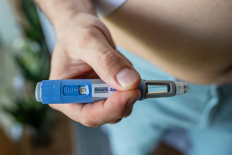 A person holds an Ozempic injectable in their hand.