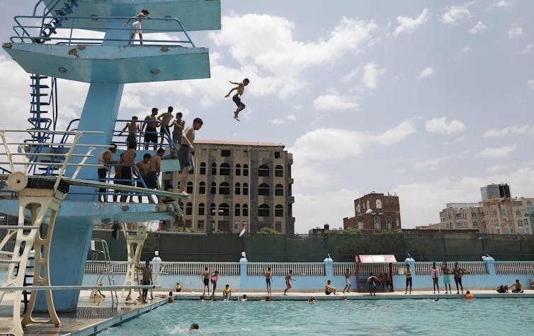 person falls from high platform toward pool'