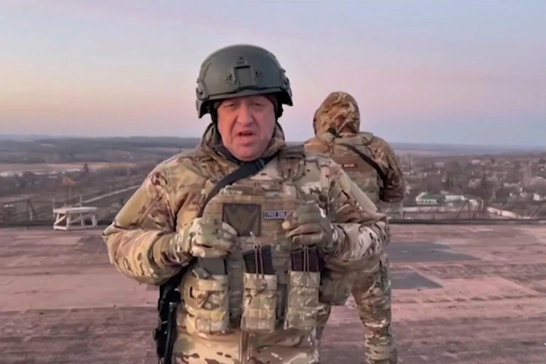 Middle aged man in combat uniform with another solider behind him