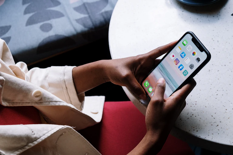 Hands seen holding a smart phone.