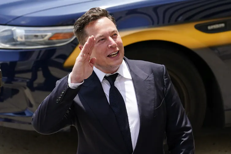 A main in suit seen raising his hand.