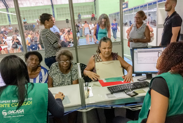 Deudoras (en su mayoría mujeres mayores y racializadas) y cobradoras (de verde), en Vitoria (Espirito Santo, Brasil) durante una feria de renegociación de deudas celebrada en diciembre de 2019.