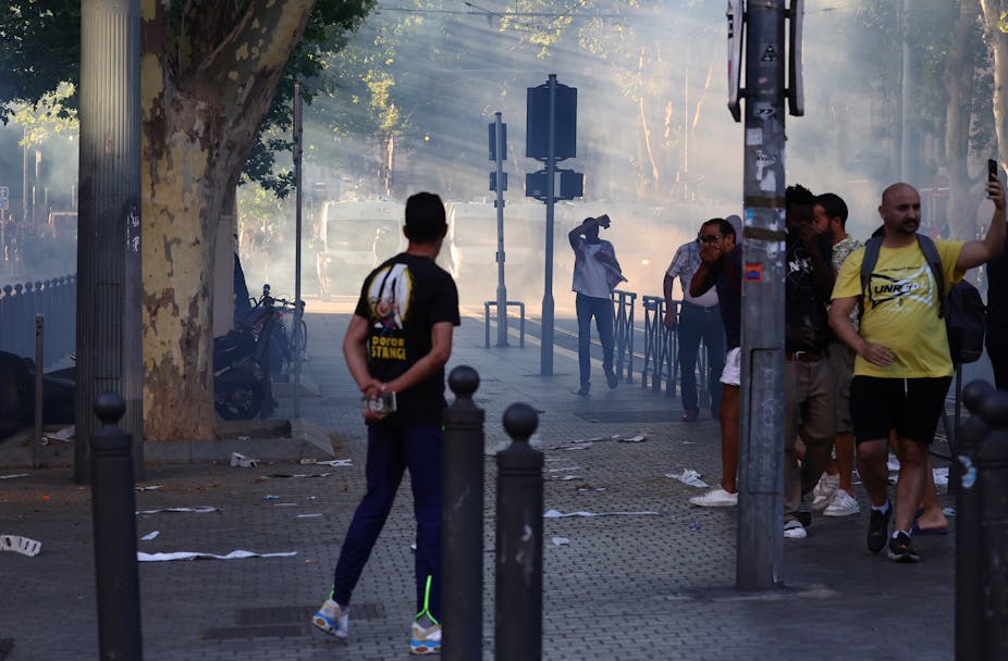 Manifestants réagissant aux grenades lacrymogènes lancées par la police anti-émeute, le 1er juillet 2023.