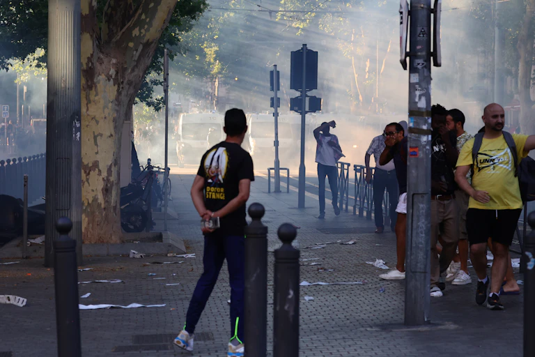 Manifestants réagissant aux grenades lacrymogènes lancées par la police anti-émeute, le 1er juillet 2023.