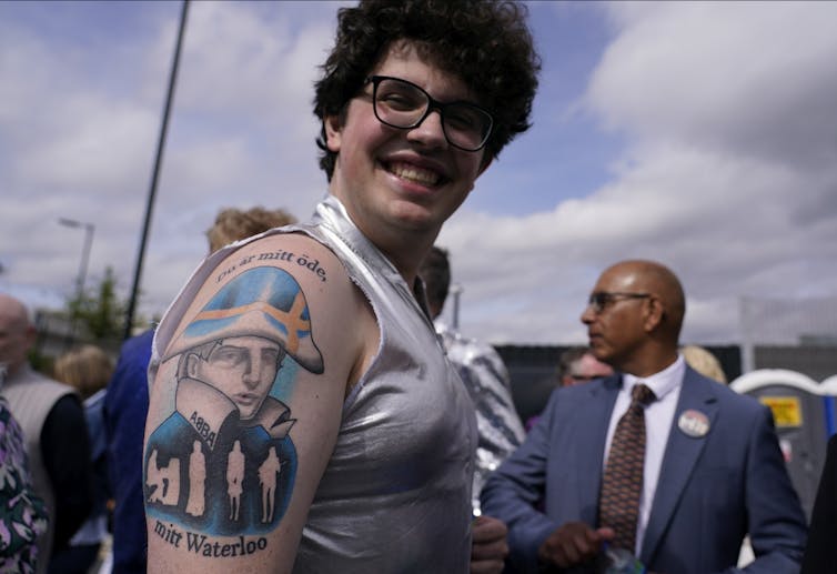 A person seen showing off a tattoo of a military figure that says 'Waterloo, ABBA.'