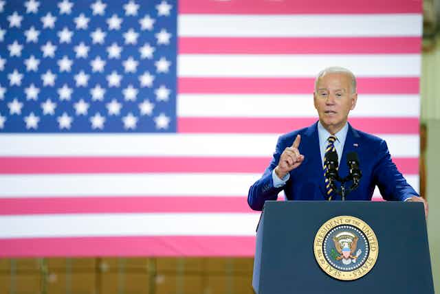 US President Joe Biden at lectern in front of US flag