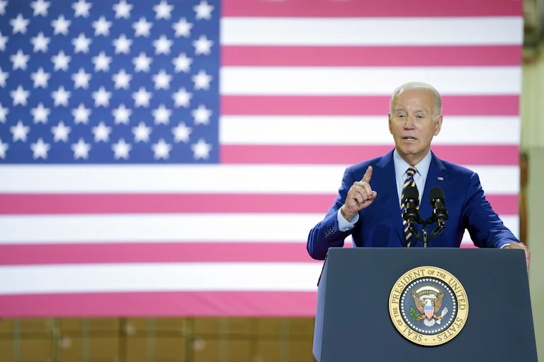 US President Joe Biden at lectern in front of US flag