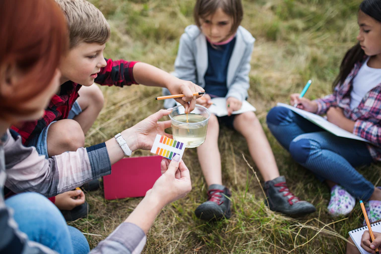 Children testing pH levels in river or lake water