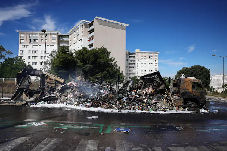Cette photographie montre un camion de marchandises endommagé et brûlé près d’un magasin Aldi dans le quartier Les Flamants, au nord de Marseille, dans le sud de la France, le 1ʳᵉ juillet 2023, après une quatrième nuit consécutive d’émeutes en France