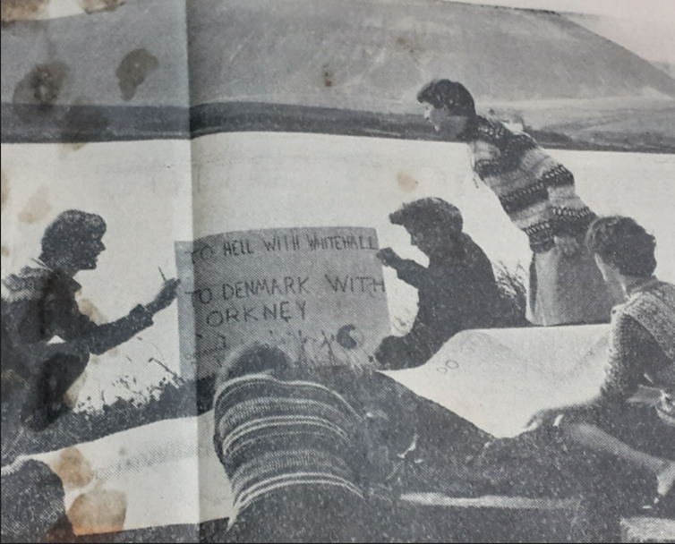 A black and white image of five people drawing protest posters in Orkney.
