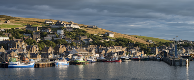 A Scottish coastal fishing village on a hillside going down to the sea.