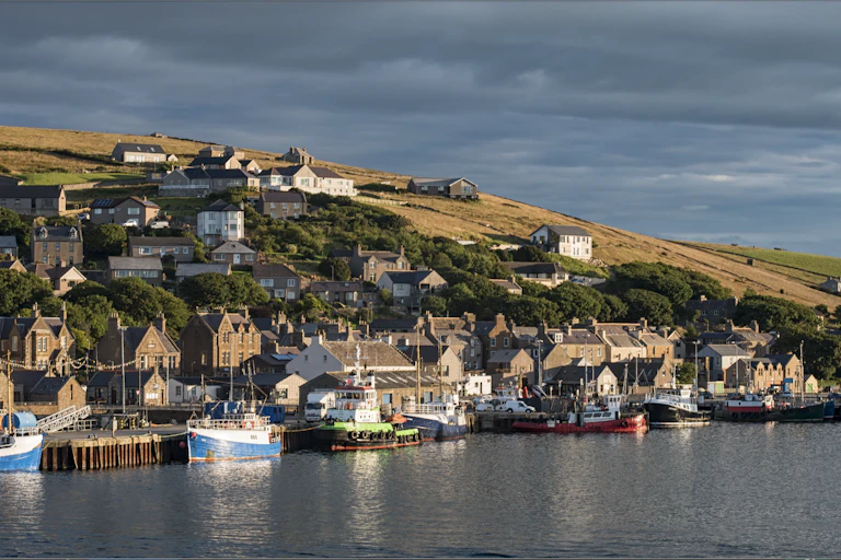 A Scottish coastal fishing village on a hillside going down to the sea.