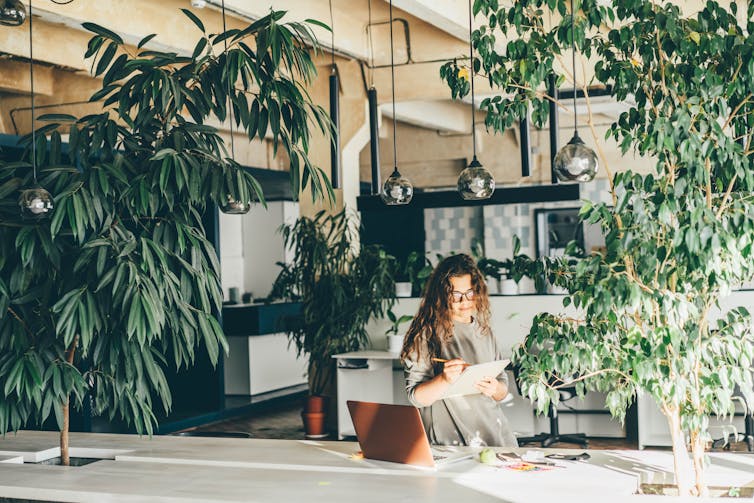 Woman at work surrounded by plants.