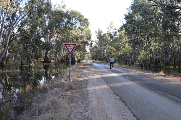 man stands on flooded road