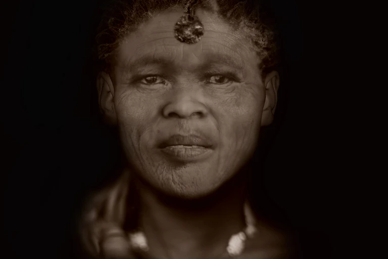 A sepia-toned portrait of a woman looking straight at the viewer
