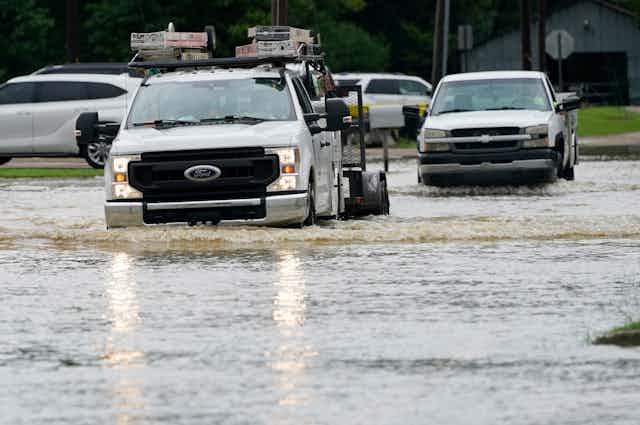 Pickups drive through water up to their bumpers