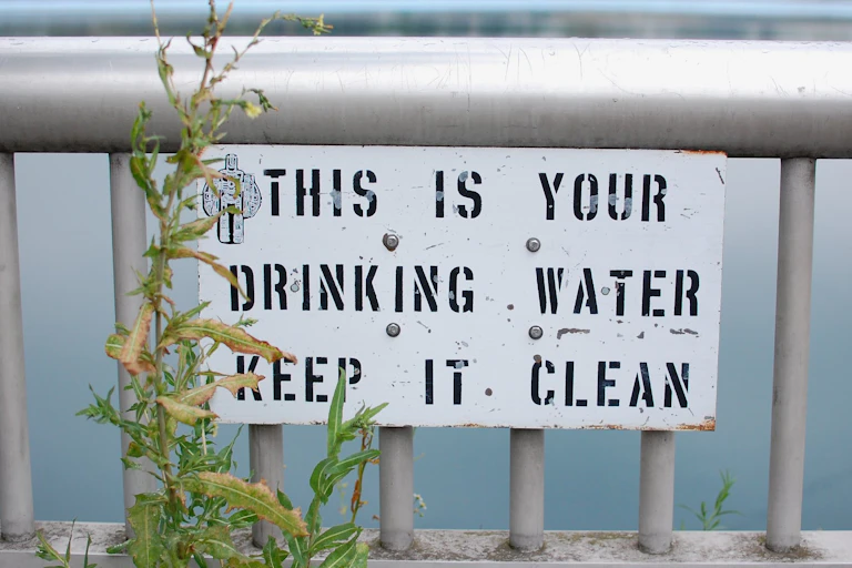 photo of sign saying this is your drinking water, keep it clean in front of reservoir