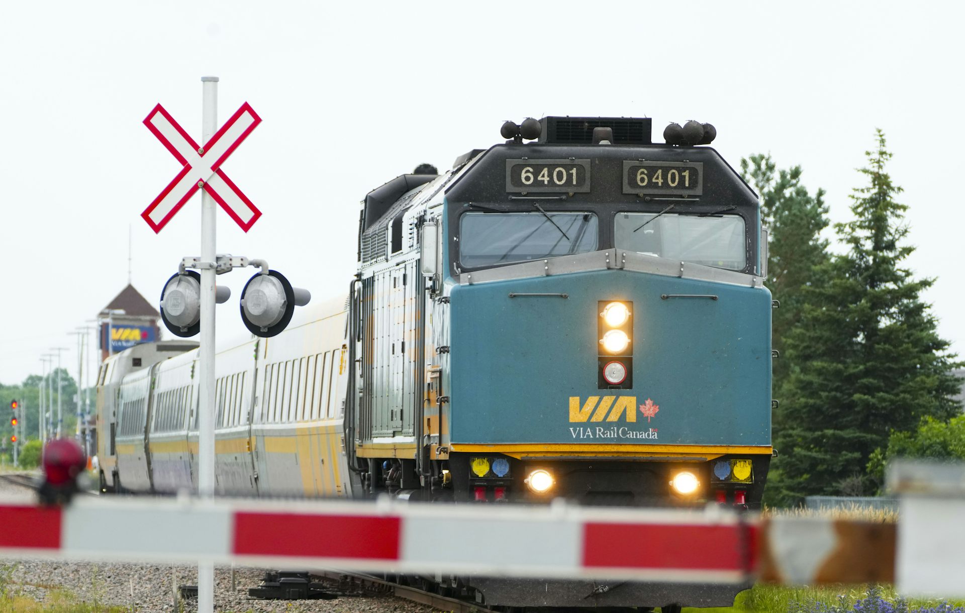 A train driving past a crossing sign on train tracks