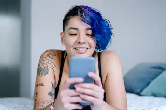A person looks at their phone and smiles.