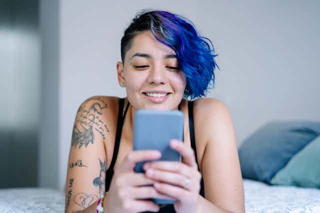 A person looks at their phone and smiles.
