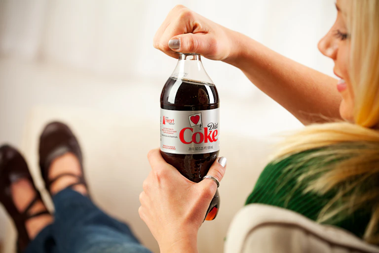 Woman opening bottle of diet Coke
