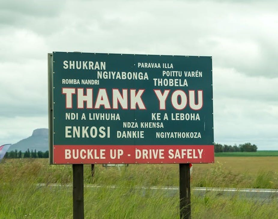 Un panneau routier demande aux usagers de "boucler leur ceinture et de conduire prudemment" en plusieurs langues.