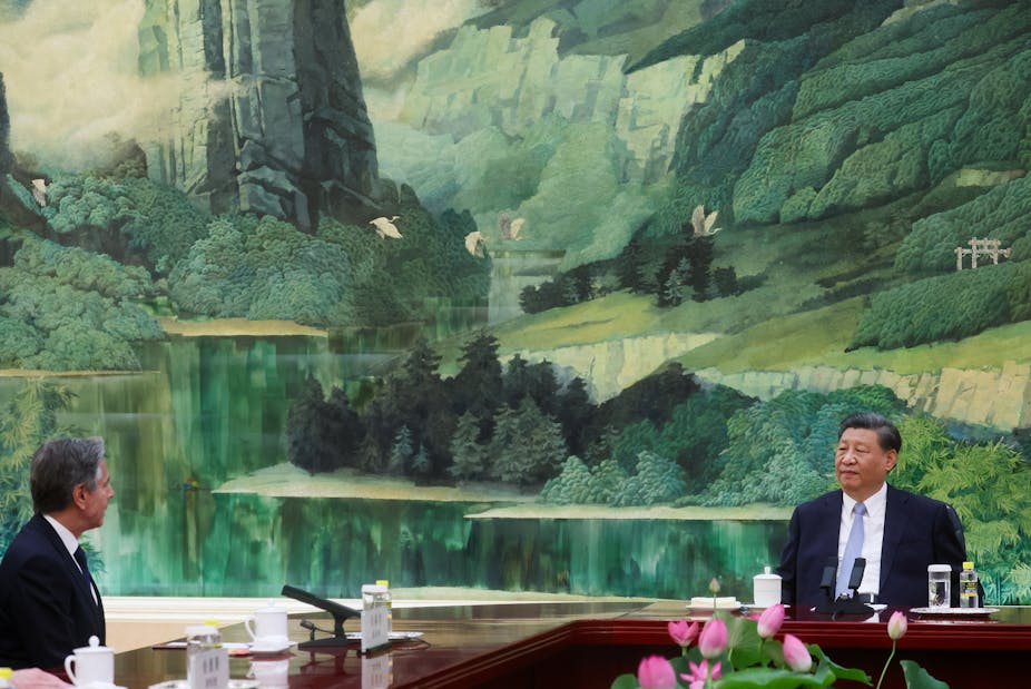 Anthony Blinken assis à une longue table avec Xi Jinping 