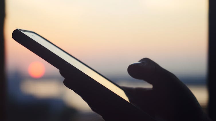 Photo of a person's hand holding a mobile phone
