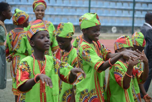 Pupils in native attire dance during the Childrens Day parade at Agege Stadium in Lagos Nigeria 