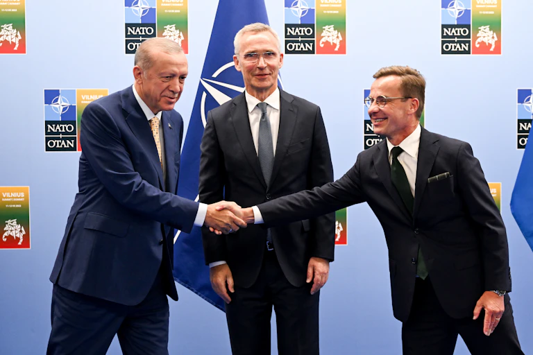 Turkish President Recep Tayyip Erdogan (left) and and Swedish Prime Minister Ulf Kristersson shake hands, as the secretary general of Nato Jens Stoltenberg looks on.