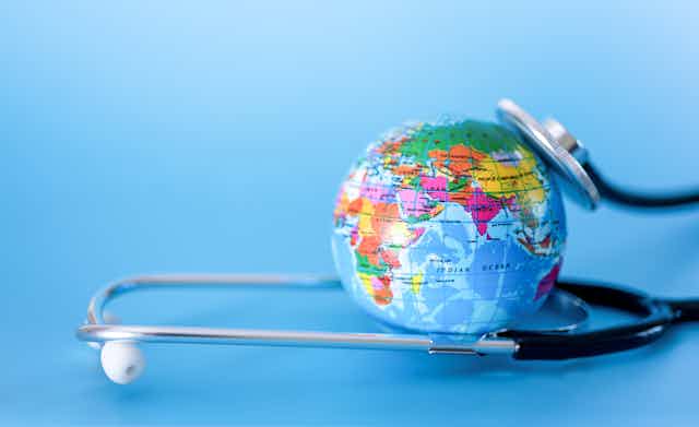 A globe and a stethoscope against a blue background