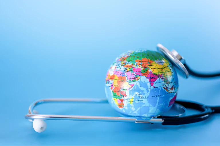 A globe and a stethoscope against a blue background