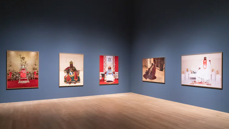 bright portraits of Nigerian Monarchs hanging on a blue wall.