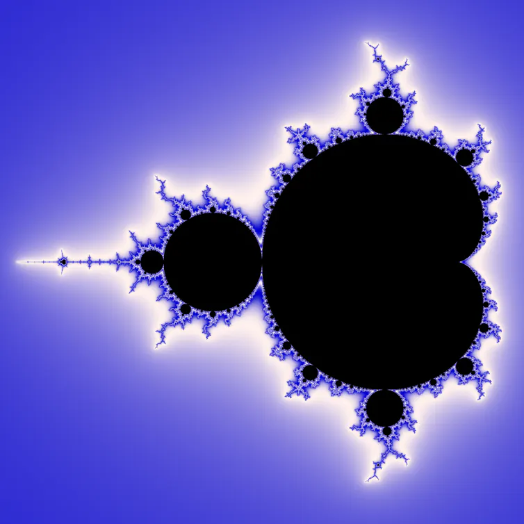 The Mandelbrot set, a mathematical fractal, shown in black against a blue background. The edges of the fractal are blue and white