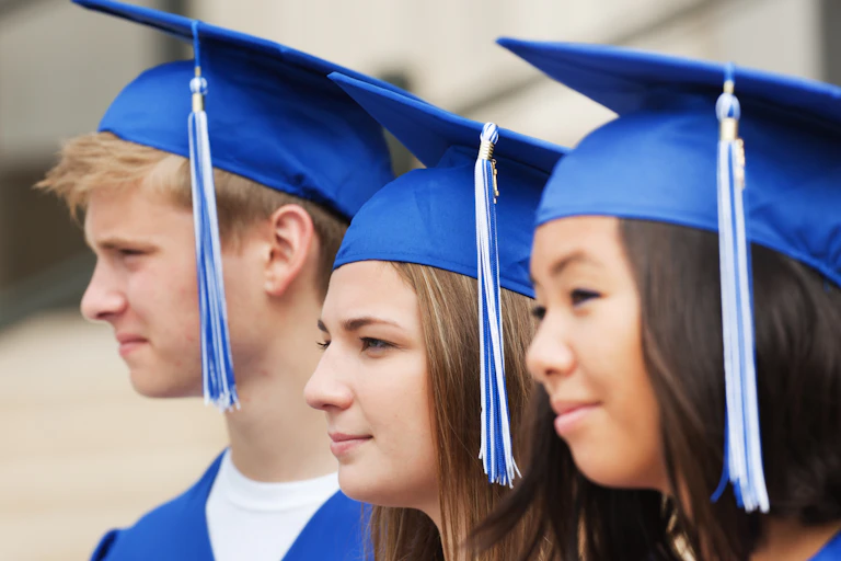 A group of students graduating students pose for a photo.