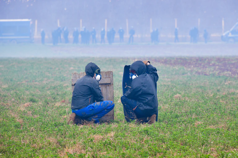 Des manifestants se protègent derrière des boucliers de fortune lors d'affrontements avec des gendarmes pendant une manifestation contre les méga-bassines, symbole des tensions autour de l'accès à l'eau, à Sainte-Soline, le 25 mars 2023.