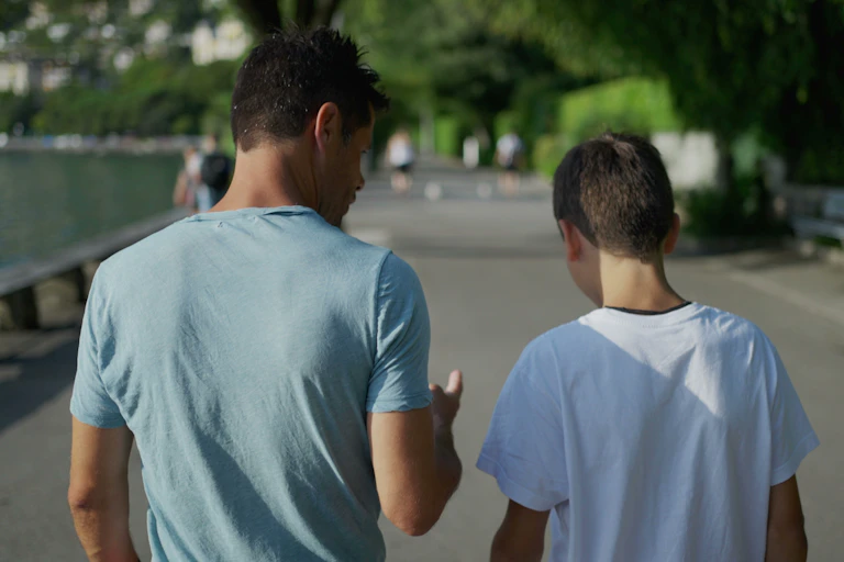 Father and son back view walking and talking