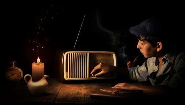 Boy adjusting old-fashioned radio