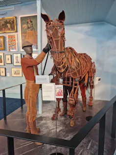 A brown bronze-looking horse puppet on display.