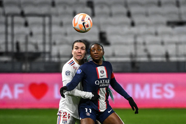 Deux footballeuses au duel, les yeux rivés sur un ballon en l'air