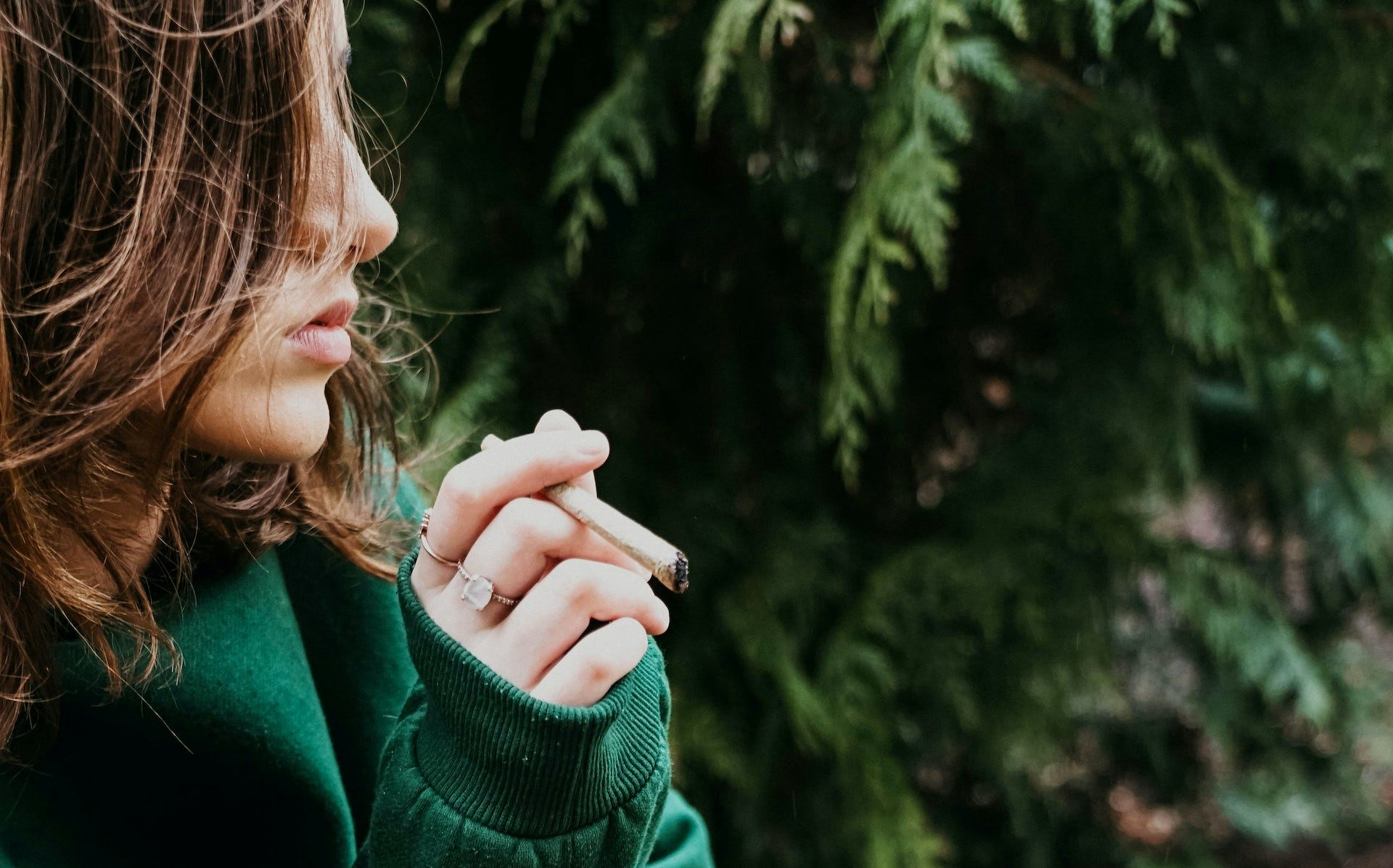 Photo d’une adolescente avec un joint de cannabis à la main.