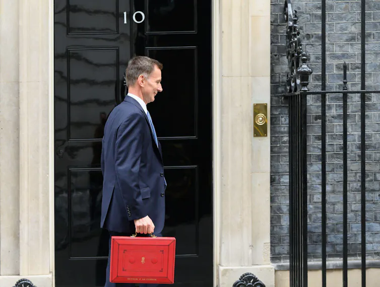 Jeremy Hunt walking past 10 Downing Street carrying his ministerial red box.